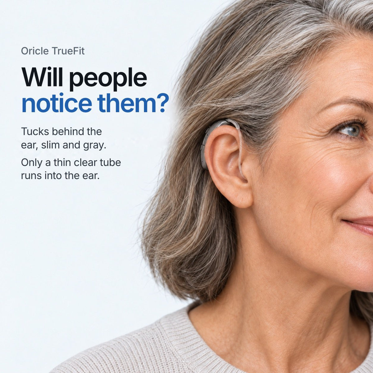 Oricle TrueFit. Will people notice them? Tucks behind the ear, slim and gray. Only a thin clear tube runs into the ear. A studio model wears the gray aid behind her ear